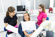 © F8  \ Suport Ukraine - Dentist and patient choosing treatment in a consultation with medical equipment in the background