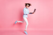 Full length body size profile side view of her she nice attractive skinny cheerful brown-haired girl jumping running study learn use laptop web conference isolated pink pastel color background