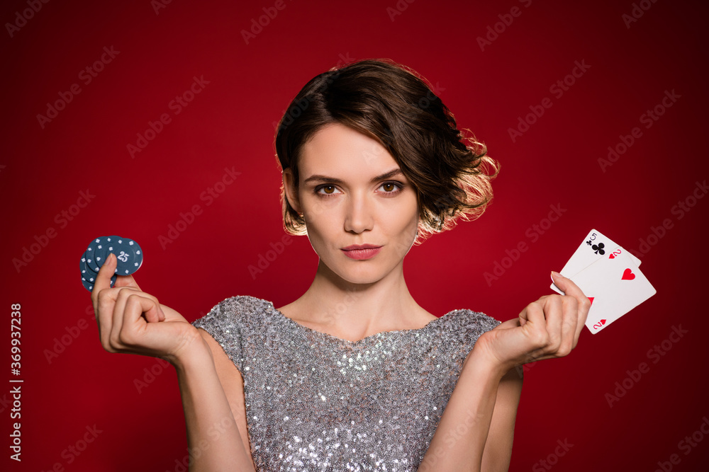 Closeup photo of tender lady casino club member professional player hold chips two deck playing cards betting risky wear shine grey dress isolated burgundy dark red gradient color background