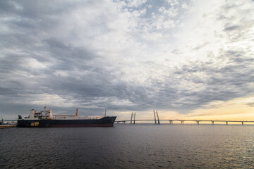 Wall Mural - Sunset landscape with cable stayed bridge and big container ship