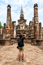 Man Taking Pictures Of An Ancient Buddhist Temple In Sukhothai, Thailand