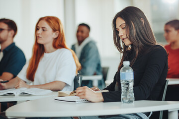 student making notes during the lecture