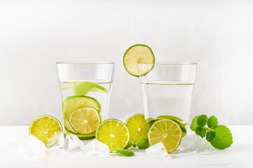 Drink glasses with water ,lime,mint and ice on white background