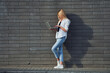 © standret - Using laptop. Beautiful blonde in casual clothes is outdoors at sunny daytime