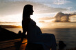 © Ruben Chase - Silhouette of a pregnant woman against an oceanic landscape