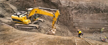 Panoramic View Of An Excavator Vehicle In Construction Site Among An Abseil Worker.
Excavation Site Where Deep Construction Foundations Will Be Made.
