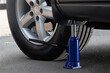 © Fobosvobos - The blue hydraulic bottle jack is installed under the machine and lifting it.