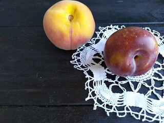 ripe red-yellow fruit peach plum on the black wooden table