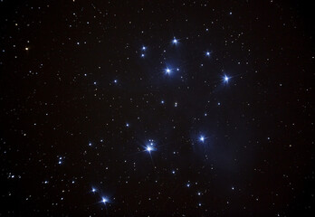 Wall Mural - The iconic Pleiades star cluster high in the night sky