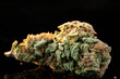 Close up of medical marijuana buds on black reflecting background at sunshine