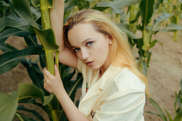 Wall Mural - Portrait of a girl in the leaves of corn. Cute girl in nature. Natural cosmetics, beauty and youth