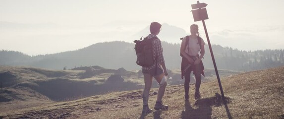friend hiking together morning sunlight hike face mask in hand point arm direction foot bump toe tap