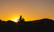 © Romano Alves - silhueta de homem a andar de moto nas montanhas ao pôr do sol
