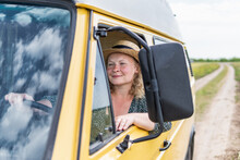 Young Blonde Woman Driving Yellow Camper Van Though The Countryside. Self Built Off-grid Motorhome.