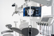 © diignat - Interior of dental practice room with chair, lamp, dental scan on the display and stomatological tools