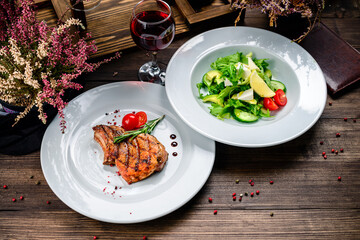 Poster - Two dishes on a wooden table - steak and salad. Set of food for lunch