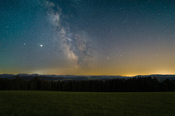 Wall Mural - The Milky Way over the Allgovia mountains as seen from the summit a mountain near Isny in Germany.
