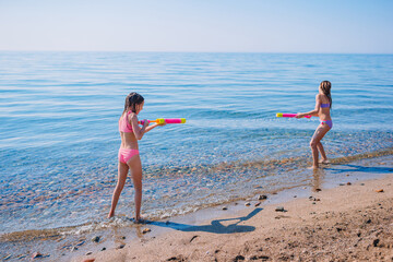 little girls having fun at tropical beach during summer vacation playing together