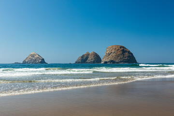 Wall Mural - Sea Stack rocks sit just off a sandy beach near Oceanside Oregon