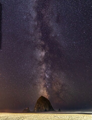Wall Mural - Vertical Image-Milky Way galaxy shines in the sky above Haystack Rock on Cannon beach in Oregon