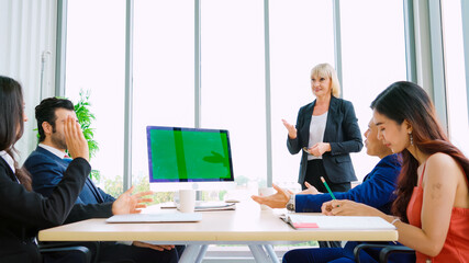 Wall Mural - Business people in the conference room with green screen chroma key TV or computer on the office table. Diverse group of businessman and businesswoman in meeting on video conference call .