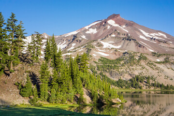 Wall Mural - volcanic mountain landscape with clear blue sky, morning light, and reflective water in the foregrou