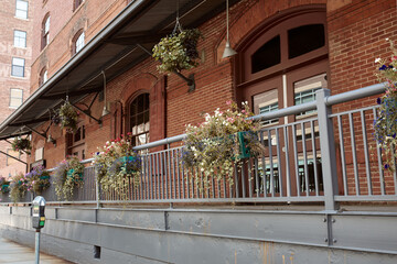 Brick facade of building with flower pots on railing in Downtown Denver.  Denver, Colorado, USA