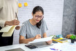 © amnaj - Two young asian in casual clothes talking and discussing working with laptop at home.