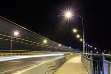 A Bridge At Night. The Light Trails Of A Passing Truck Create Surreal Streaks In The Air