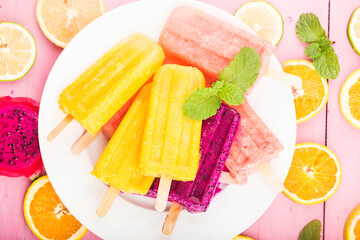 Wall Mural - Various fresh fruit popsicles placed on wooden board background