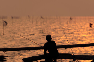 Wall Mural - The fisherman silhouette with sunset sky