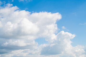 Blue skies on a clear day. White cumulus clouds float across the sky.