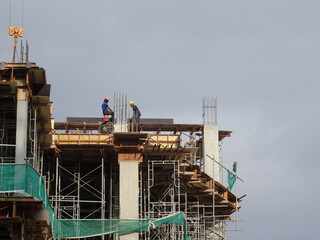 Wall Mural - KUALA LUMPUR, MALAYSIA -AUGUST 23, 2019: Construction workers working at the construction site in Malaysia during the daytime. They are required to wearing appropriate safety gear to avoid an accident