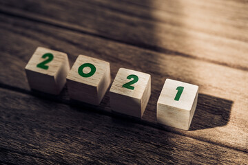 Aufkleber - 2021 happy new year on wood block on wood table and concrete wall with sunlight from window.hope new year concept