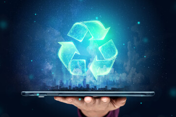 Sign Recycling hologram over the tablet on the hand. Eco recycling green symbol. The concept of clean land, garbage disposal.