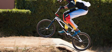 BMX Rider Competing In The Child Class On The Off-road Circuit