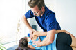 © Louis-Paul Photo - Male Physical Therapist Stretching a Female Patient