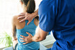 © Louis-Paul Photo - Male Physical Therapist Stretching a Female Patient Slowly.