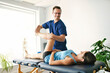 © Louis-Paul Photo - Male Physical Therapist Stretching a Female Patient