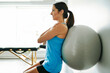 © Louis-Paul Photo - young woman doing exercise on fitness ball at the physiotherapy office