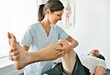 © Louis-Paul Photo - physiotherapist doing treatment with patient in bright office with leg training