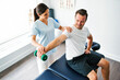 © Louis-Paul Photo - physiotherapist doing treatment with patient in bright office