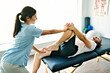 © Louis-Paul Photo - physiotherapist doing treatment with patient in bright office with leg training