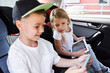 © Yakobchuk Olena - Jolly siblings playing with gadgets in car