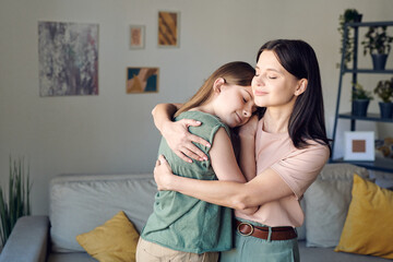 Poster - Young loving mother embracing her cute affectionate daughter in home environment