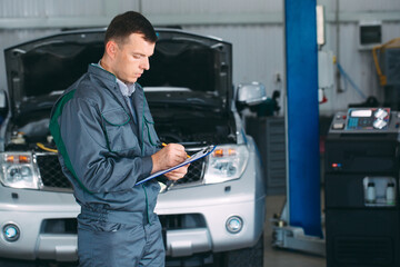 Wall Mural - mechanic maintaining car record on clipboard at the repair shop.