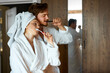 © alfa27 - just woke up couple brushing their teeth together, woman with towel after bath stand with man looking on mirror, morning