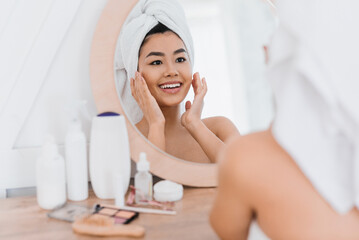 Wall Mural - Pretty asian girl applying cream on her face