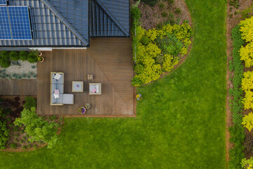 Wall Mural - Top view of suburban house with green garden and wooden terrace