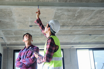 Worker inspector is checking with checklist and pointing new building with customer or client inspection and engineering concept